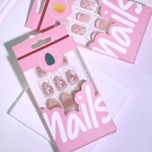 Pink press-on nail kit featuring floral and polka dot designs in a branded box