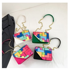 Detailed flat lay of stylish crossbody bags with colorful geometric patchwork and gold chains