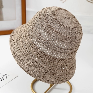 Close-up detail of beige hollow-out knitted bucket hat featuring intricate mesh pattern