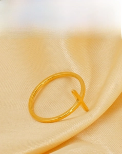 Macro detail of 18K gold plated stainless steel ring with minimalist criss-cross design