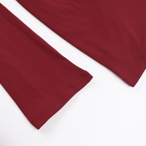 Gros plan sur les coutures à double aiguille de l'ourlet de cette robe bordeaux