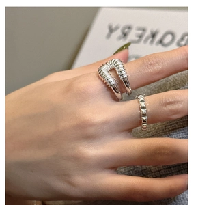 Detalle de los anillos de plata esterlina S925 con diseño envolvente y texturas de remaches