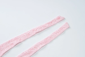 Close-up of pink lace stockings featuring intricate floral patterns and scalloped edges