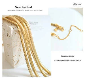 Detailopname van gelaagde gouden slangenketting met karabijnsluiting en ronde M-hanger