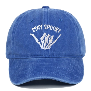 Washed blue baseball cap featuring white Stay Spooky skull embroidery and a curved brim