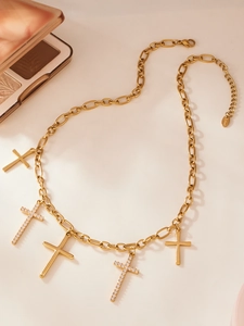 Détail du collier en acier plaqué or 18 carats avec cinq pendentifs croix et zircons