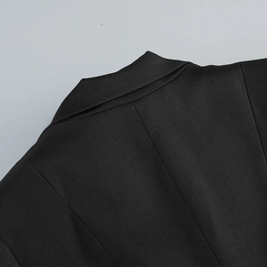 Close-up of black blazer dress showing twill fabric texture and collar stitching details