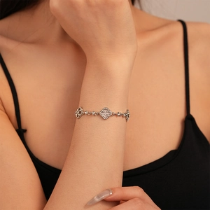 Detailed view of silver adjustable clover bracelet with sparkling zircons and mother of pearl