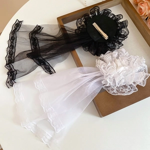 Detail of elegant black and white lace Lolita hair clips with mesh veils on wooden frame