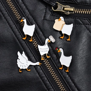 Detailed enamel pins of funny white geese on black leather jacket with sharp metallic edges