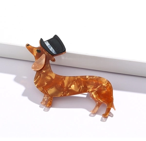 Detail of dachshund brooch in amber acetate with hat on white minimalist stage