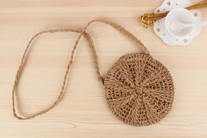 Top view of a round woven paper rope bag with detailed texture on a light wood surface