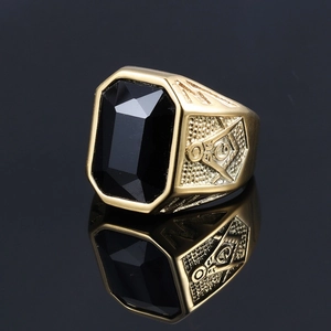 Close-up of gold Freemason ring featuring a large rectangular black gemstone and G emblem