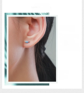 Détail macro de boucles d'oreilles tortue avec gemme bleu mer et fini argenté