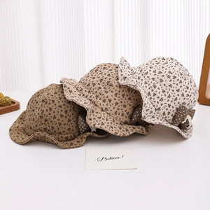 Detailed close-up of floral baby sun hats in khaki and cream with dotted bow accents
