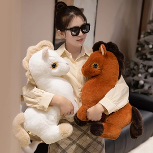 Soft plush white and brown horse stuffed animals held by a model in a cozy home setting