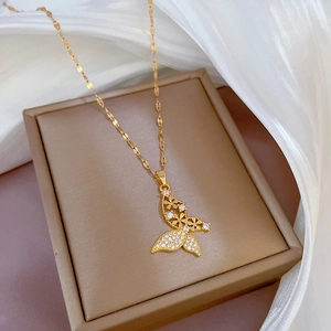 Detail of a luxury gold butterfly pendant with micro-pave zircons on a silk background