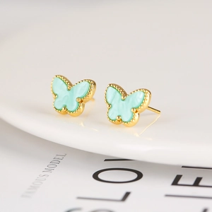 Detailed close-up of light mint green butterfly stud earrings with golden edges