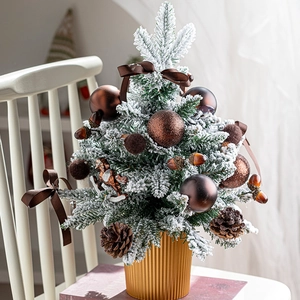 Miniature snow-flocked Christmas tree with pine cones and bronze base for home decor