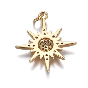 Macro detail of a golden star pendant with sparkling pavé zircon center on white background