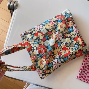 Detailed close-up of floral cotton tote bag featuring colorful patterns and metal clasp
