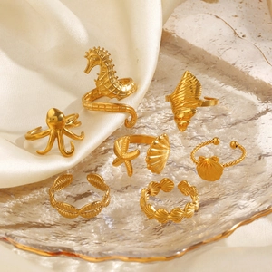 Golden stainless steel ocean ring set with starfish and octopus on white satin