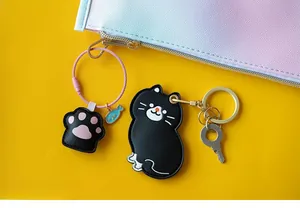 Détail de porte-clés chat noir et patte en cuir avec des fermoirs en métal doré