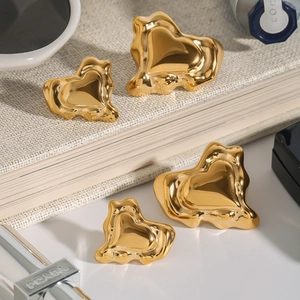 Détail de boucles d'oreilles cœur en or liquide avec finition miroir métallique