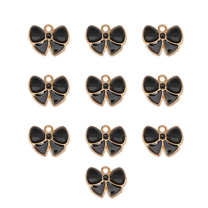 Macro view of ten black and gold enamel bow charms for DIY jewelry making and crafts