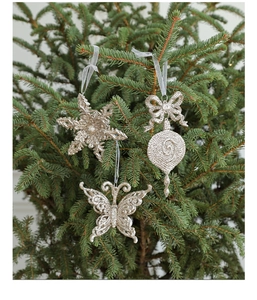 Champagne gold Christmas ornaments with snowflakes and bows hanging on a green tree