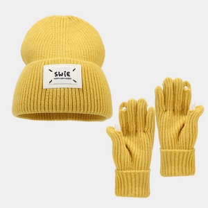 Detail of yellow knit hat and touchscreen gloves set with SWiE patch and white fingertips