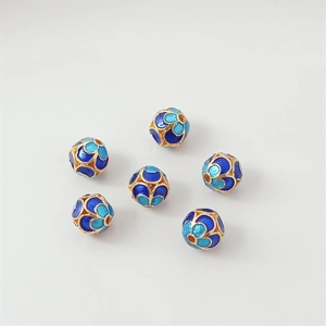 Macro shot of 18K gold-plated Cloisonne beads with blue floral patterns for DIY jewelry