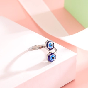 Adjustable silver evil eye open ring featuring dual blue circular charms on minimalist stand