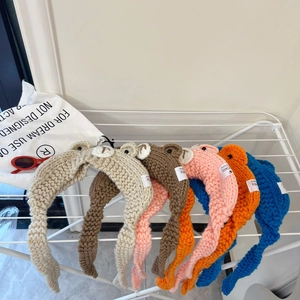 Detail of colorful knit animal ear headbands in beige brown pink orange and blue colors