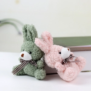 Detail of soft green and pink plush rabbit pendants with checkered bows and bead chains
