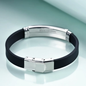 Macro shot of silver stainless steel clasp on a minimalist black rubber bracelet