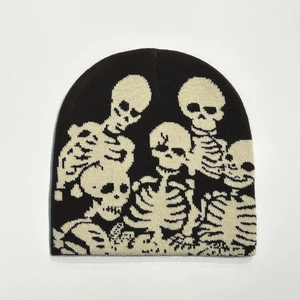 Detail view of black knitted beanie with multiple white skull patterns for Halloween