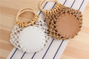 Detailed view of hand-woven mesh beach bags with round wooden handles in white and tan