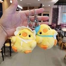 Detailed close-up of cute yellow plush chicken keychains with soft hats and metal clips