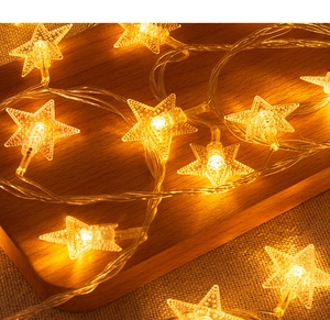 Macro detail of warm yellow LED star lights on transparent wire for outdoor decoration