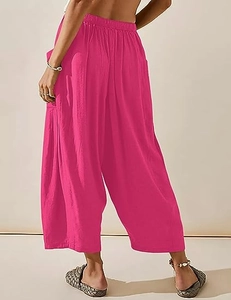 Vue de dos du mannequin portant un pantalon large rouge rose en lin à taille haute en studio