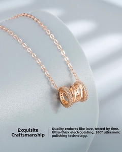 Macro view of rose gold interlocking triple rings with micro-set zircons on necklace