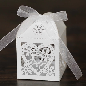 Detailed laser-cut heart and floral patterns on white paper gift box with organza ribbon