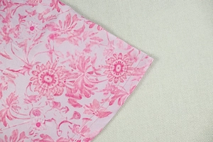 Zoom sur les coutures à double aiguille de l'ourlet d'une robe trapèze à fleurs roses
