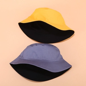 Detail of solid color reversible bucket hats with reinforced stitching on the brim