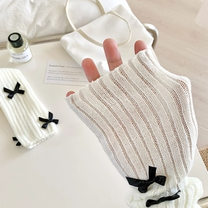Gros plan sur des jambières en tricot côtelé blanc avec nœuds en soie noire élégants