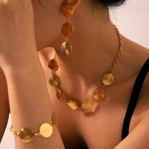 Golden jewelry set with spiral round charms including necklace, earrings, and bracelet