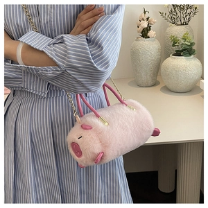 Dettaglio della borsa a maialino in peluche rosa con catena dorata e consistenza soffice