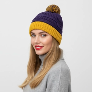 Détail du bonnet d'hiver en grosse maille violette et jaune avec pompon bicolore