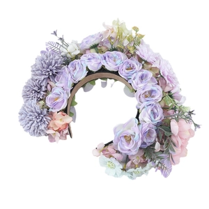 Elegant purple and white artificial flower headpiece with green leaves on a brown headband